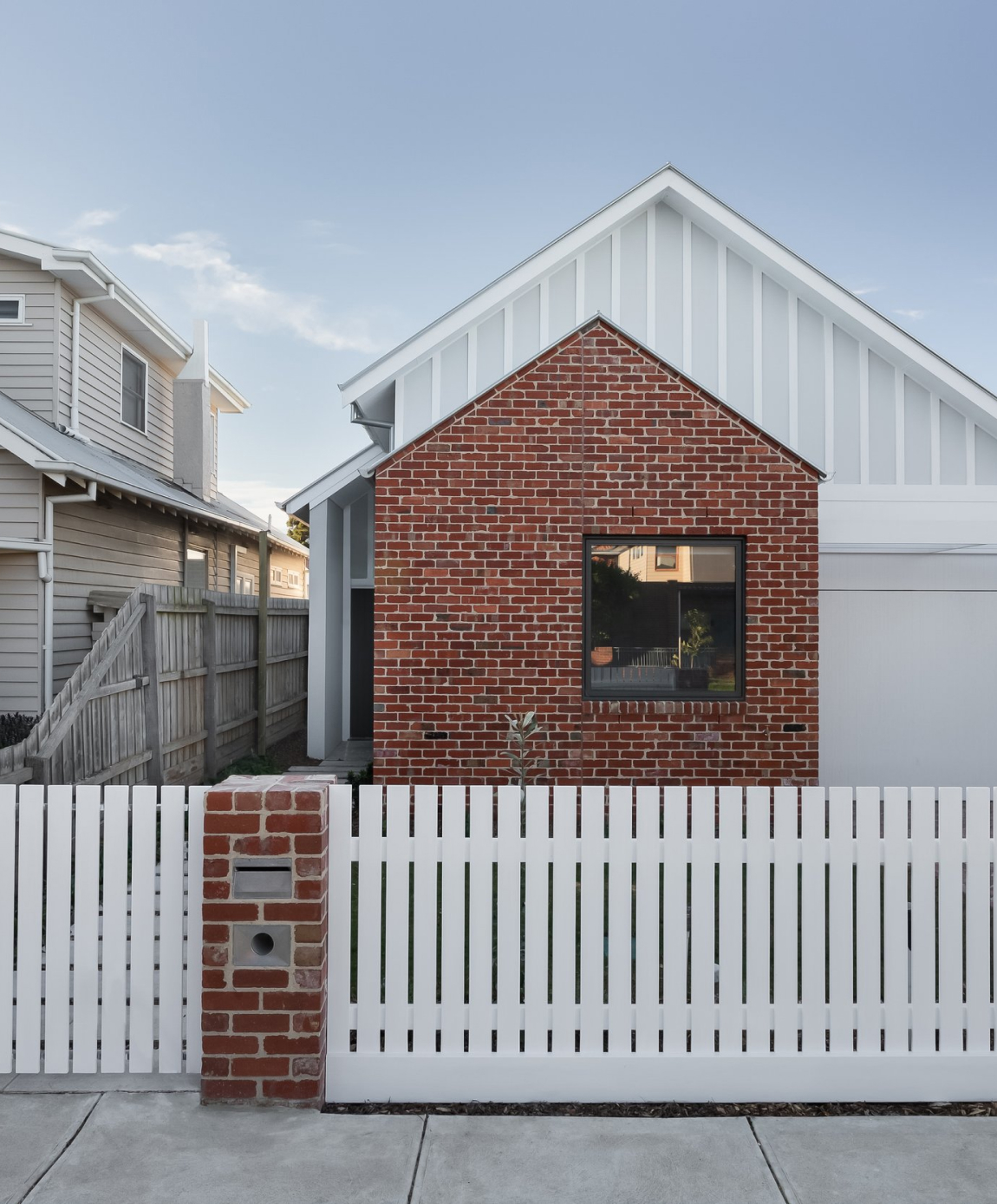 Knock down Rebuild home with red brick and picket fence